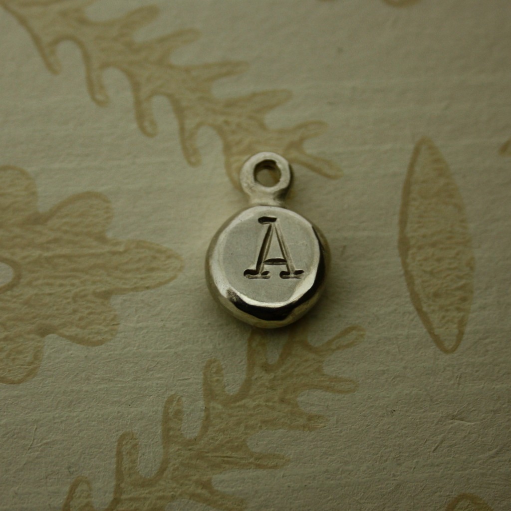 Round silver nugget hand stamped with an initial letter