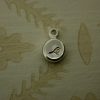 Round silver pebble hand stamped with a bird symbol