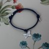 silver butterfly charm tied on a waxed cotton cord with sliding knots