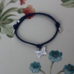 silver butterfly charm tied on a waxed cotton cord with sliding knots
