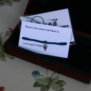 Silver bird box charm on a length of waxed cotton cord on a quote card